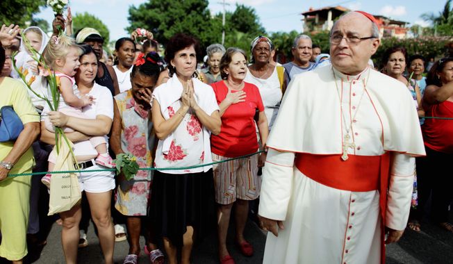Cardinal Jaime Ortega attends a procession honoring the nation&#x27;s patron saint, the Virgin of Charity of Cobre, in Havana on Nov. 10. A political cartoon that appeared in Miami&#x27;s El Nuevo Herald showed the cardinal and a military-clad Cuban President Raul Castro singing a love song together, implying that the religious leader was a Castro lackey. (Associated Press)