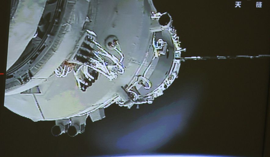 In this image made off the screen at the Beijing Aerospace Control Center and released by China&#39;s Xinhua News Agency, China&#39;s Shenzhou-9 manned spacecraft (left) docks with the Tiangong-1 space lab module shortly after 2 p.m. Beijing time (2 a.m. EDT) on Monday, June 18, 2012, 213 miles above Earth. (AP Photo/Beijing Aerospace Control Center via Xinhua)