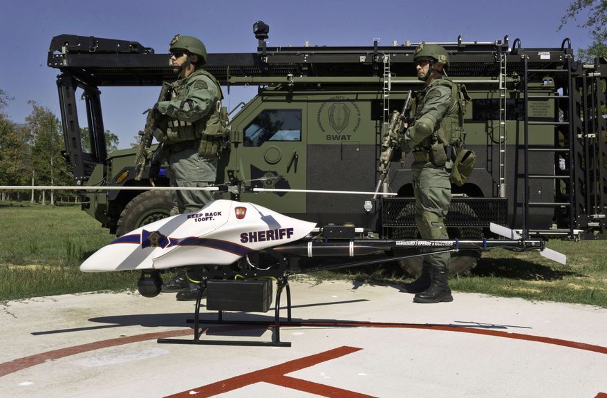 ** FILE ** This September 2011 file photo provided by Vanguard Defense Industries, shows a ShadowHawk drone with Montgomery County, Texas, SWAT team members. The prospect that thousands of drones could be patrolling U.S. skies by the end of this decade is raising the specter of a Big Brother government that peers into backyards and bedrooms. (AP Photo/Lance Bertolino, Vanguard Defense Industries)
