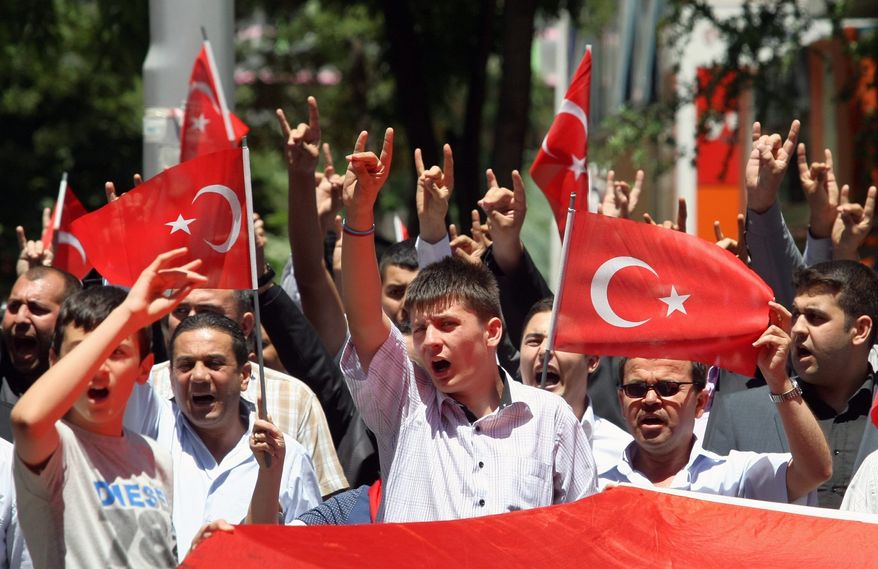 Turks hold national flags as they march in Ankara on Wednesday. They were protesting the deaths of soldiers a day earlier, when Kurdish rebels attacked Turkish military units with mortars and rocket-propelled grenades in the Daglica area of Hakkari province, which borders northern Iraq Kurdish areas in southeastern Turkey. Reportedly, at least eight soldiers and 26 rebels died. (Associated Press)