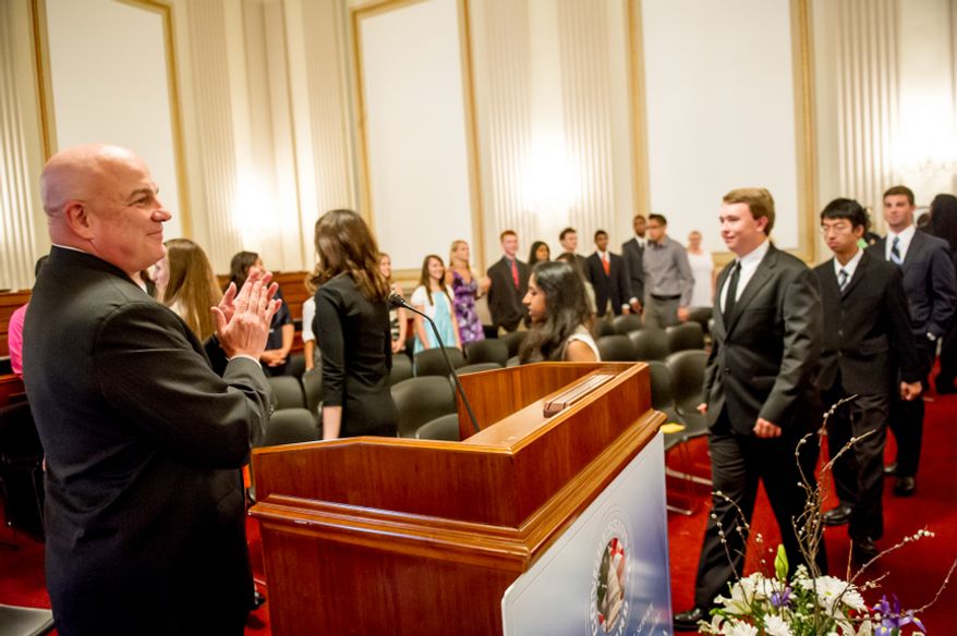 Thomas P. McDevitt, President of the Washington Times Newspaper, left, welcomes youth before they are awarded the Congressional Award Gold Medal during an award ceremony in the Cannon House Office Building on Capitol Hill, Washington, D.C., Wednesday, June 20, 2012. The 276 youth honored this year in the annual award ceremony for completing 400 hours of Voluntary Public Service activities, 200 hours each of Personal Development and Physical Fitness activities, as well as an Expedition and Exploration activity were greeted by members of congress as well as Verdine White and Ralph Johnson, two members of Earth, Wind, and Fire. (Andrew Harnik/The Washington Times)