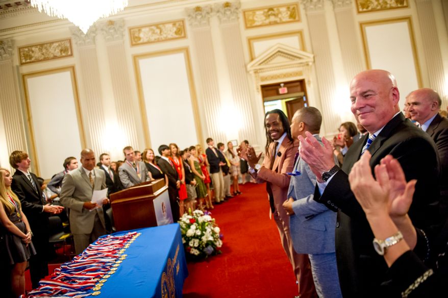 Thomas P. McDevitt, President of the Washington Times Newspaper, right, acts as the Master of Ceremonies as youth are awarded the Congressional Award Gold Medal during an award ceremony in the Cannon House Office Building on Capitol Hill, Washington, D.C., Wednesday, June 20, 2012. The 276 youth honored this year in the annual award ceremony for completing 400 hours of Voluntary Public Service activities, 200 hours each of Personal Development and Physical Fitness activities, as well as an Expedition and Exploration activity were greeted by members of congress as well as Verdine White and Ralph Johnson, two members of Earth, Wind, and Fire. (Andrew Harnik/The Washington Times)