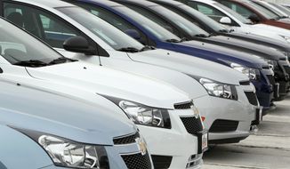 **FILE** A line of 2012 Chevrolet Cruze sedans sits Feb. 19, 2012, at a dealership in the south Denver suburb of Englewood, Colo. (Associated Press)