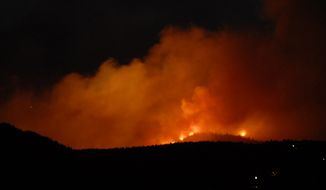The evening sky glows orange with smoke and flames as the Waldo Canyon Fire rages west of the Garden of the Gods near Colorado Springs, Colo., on Saturday, June 23, 2012. ( AP Photo/Bryan Oller)