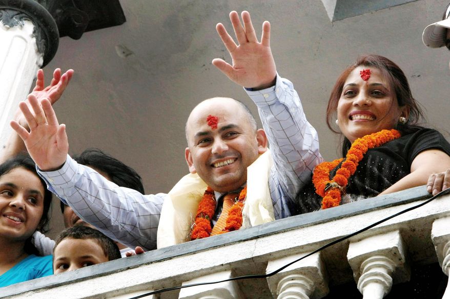 Govinda Prasad Mainali, with his wife Radha (right), waves upon his arrival at his home in Katmandu, Nepal, on June 16. Mainali, 45, spent 15 years in a Japanese jail for the murder of a Japanese woman in 1997. He was freed by the Tokyo High Court based on new DNA testing that cleared him. (Associated Press)