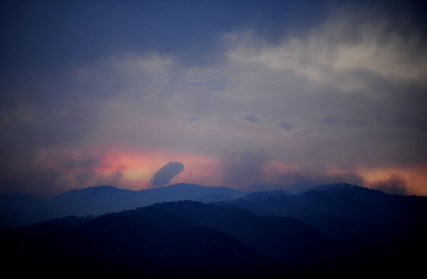 Wildfires burn west of Colorado Springs, Colo. on Sunday, June 24, 2012, as the sun sets. (AP Photo/Colorado Springs Gazette, Susannah Kay)