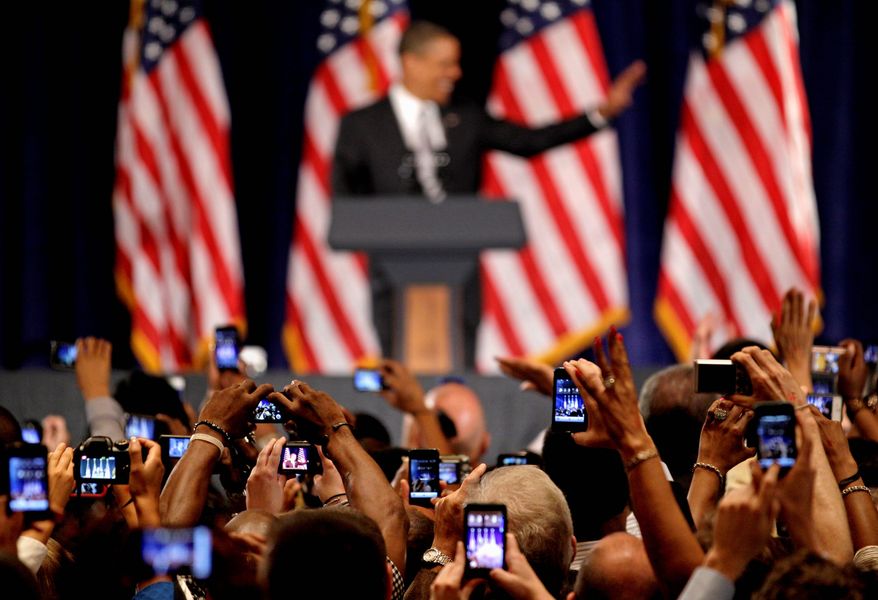 Cameras snap President Obama as he waves from the lectern at a fundraising event Tuesday in Atlanta. The president has been pushing hard for campaign contributions. (Associated Press)