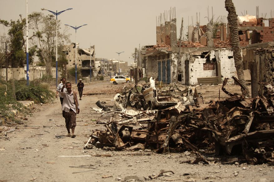 **FILE** A Yemeni man walks June 14, 2012, past cars destroyed during fighting with al Qaeda militants in Zinjibar, Yemen. (Associated Press)