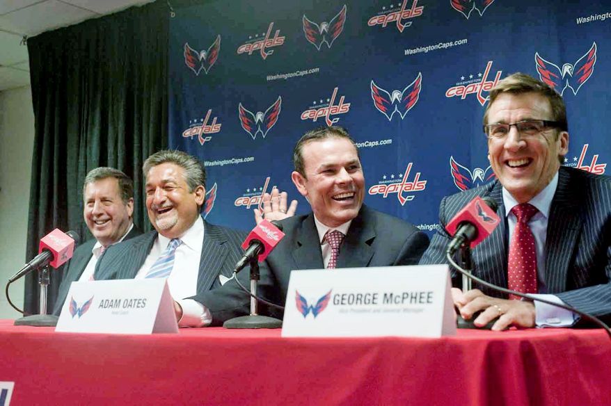 Capitals president Dick Patrick (left) , owner Ted Leonsis (second from left) , and general manager George McPhee (right) enjoy a light moment as Adam Oates is introduced as the team's coach at Verizon Center. Oates played parts of six seasons with Washington from 1997-2002. (Raymond Thompson/The Washington TImes)