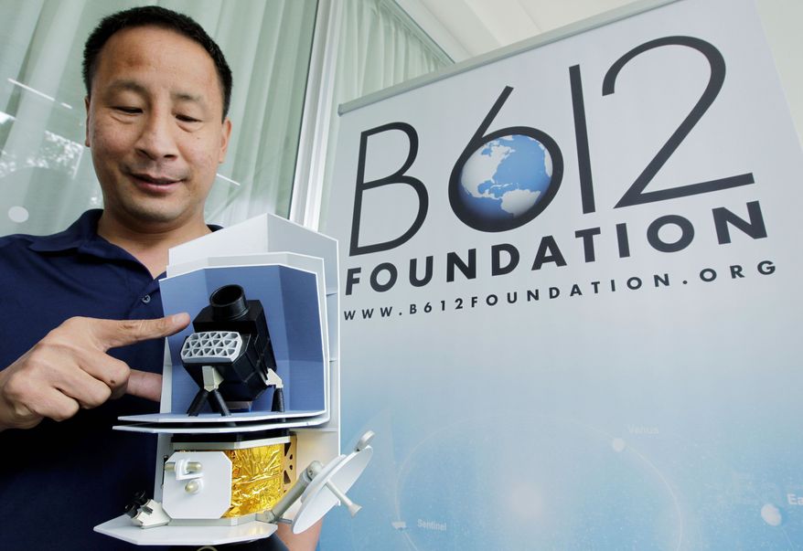 Ed Lu, Chairman of the B612 Foundation, shows a model Thursday of the Sentinel Space Telescope. A group of ex-NASA astronauts and scientists plan to launch the telescope to search for asteroids that may pose a danger to Earth. (Associated Press)