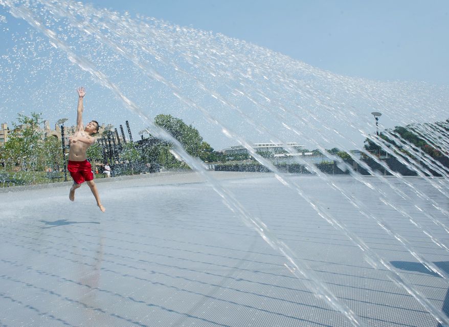 Declan Faris, 10, of Alexandria finds a great way to beat the heat while frolicking in the fountain at the Georgetown Waterfront Park on Thursday, June 28, 2012. (Barbara L. Salisbury/The Washington Times)