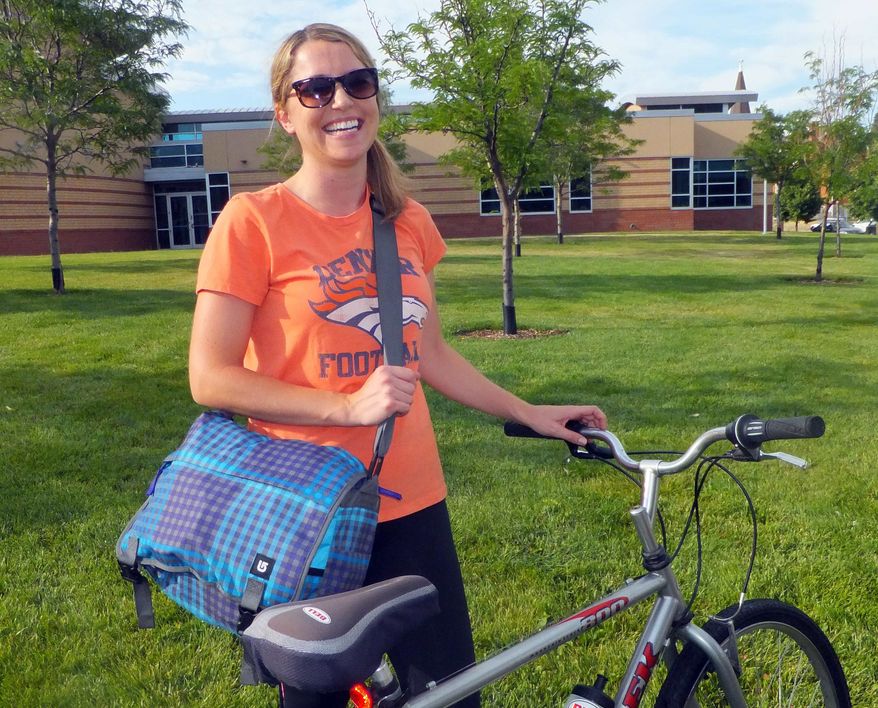 Jaclyn King, 28, smiles as she arrives at her job at a Denver hospital on Wednesday, June 27, 2012. King grew up in the suburbs of Denver and now lives in the city and says she’ll never return to the suburbs because she wants to avoid the long commutes her parents had. (AP Photo/Kristen Wyatt)