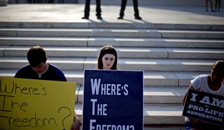 **FILE** Rachel Del Guidici, 18, of Shreve, Ohio, and others demonstrate June 28, 2012, against President Obama&#x27;s health care law outside the Supreme Court in Washington. (Associated Press)