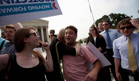Donny Kirsch of Washington gets a hug as he celebrates the Supreme Court decision on health care, Thursday, June 28, 2012, in Washington.  (AP Photo/Evan Vucci)