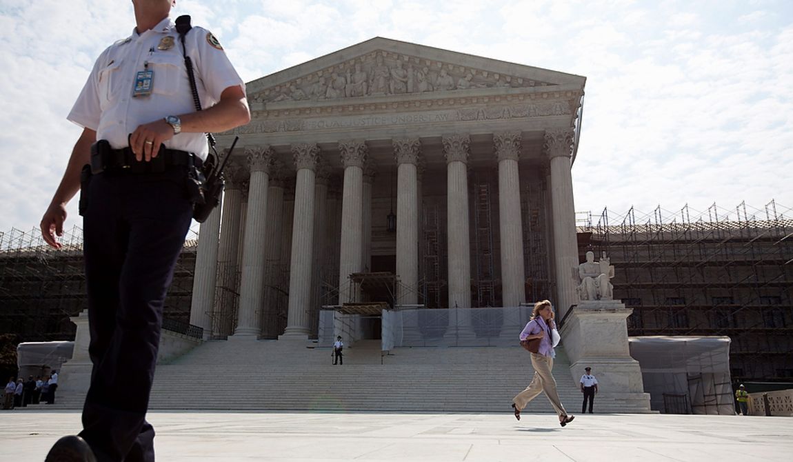 A journalist runs a copy of the Supreme Court decision on health care to her colleagues, Thursday, June 28, 2012, in Washington.  (AP Photo/Evan Vucci)
