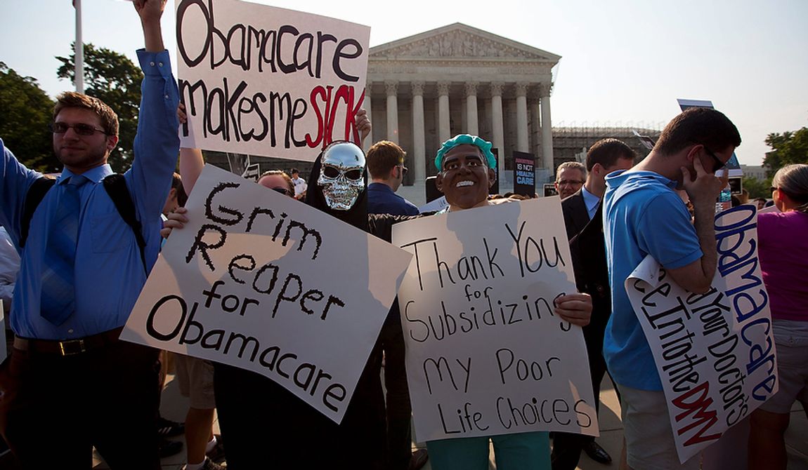 Demonstrators stand outside the Supreme Court in Washington, Thursday, June 28, 2012, before the court&#x27;s ruling on health care.  (AP Photo/Evan Vucci)