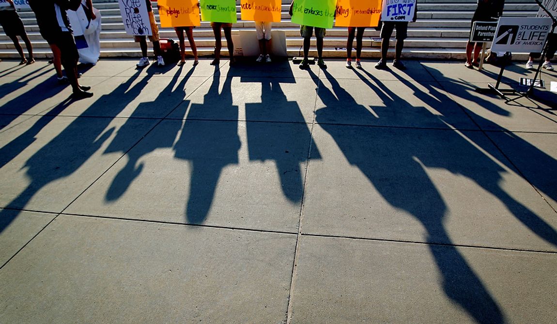 Protestors shadows are cast outside the Supreme Court in Washington, Thursday, June 28, 2012, in Washington, as the Supreme Court is expected to announce its verdict on President Barack Obama&#x27;s health care law. (AP Photo/David Goldman)