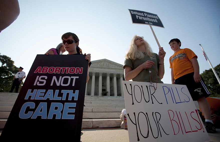 Demonstrators pray outside the Supreme Court in Washington, Thursday, June 28, 2012, before a landmark decision on health care.  (AP Photo/Evan Vucci)