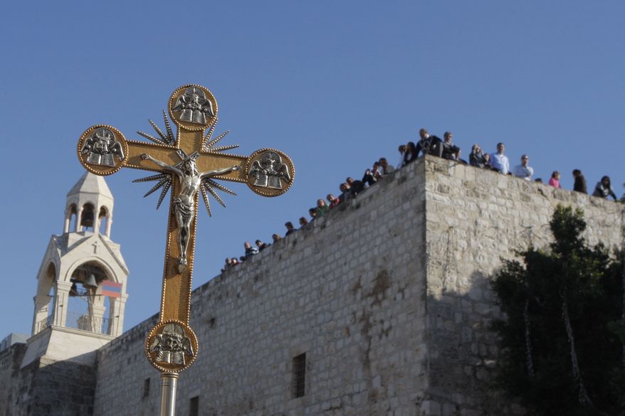 ** FILE ** In this Friday, Dec. 24, 2010, file photo, a cross is seen near the Church of Nativity, traditionally believed by Christians to be the birthplace of Jesus Christ, during a Christmas parade in the West Bank town of Bethlehem. (AP Photo/Nasser Shiyoukhi, File)