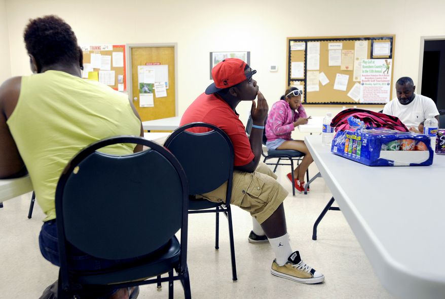 Deveon Brown (center) waits in a temporary shelter at the Boonsboro Volunteer Fire and Rescue Co. Inc. in Bedford County, Va., Friday June 29, 2012. Brown and other extended family members are visiting from Norfolk and have been staying at Eagle Eyrie nearby. A wave of violent storms sweeping through the mid-Atlantic following a day of record-setting heat in Washington, D.C., has knocked out power to nearly 2 million people. The storms converged Friday night on Washington, D.C., Maryland, Virginia and West Virginia. West Virginia Gov. Earl Ray Tomblin declared a state of emergency after more than 500,000 customers in 27 counties were left without electricity. (AP PHOTO/Photo by Parker Michels-Boyce, The News & Advance)
