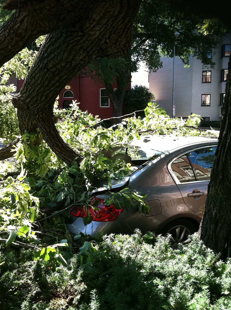 A tree toppled by severe storms sits atop a car in Washington's Dupont Circle neighborhood on Saturday, June 30, 2012, in Washington. More than two million people across the eastern U.S. lost power after violent storms and two people died, including a 90-year-old woman asleep in bed when a tree slammed into her home, a police spokeswoman said Saturday. (AP Photo/Jessica Gresko)