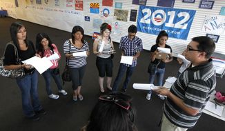 Brian Conklin (far right), a regional campaign director for the re-election of President Obama, briefs volunteers about registering new voters prior to them canvassing a heavily Latino neighborhood in Phoenix. Across the country both political parties have been courting the Latino vote, the nation&#39;s fastest-growing minority group. (AP Photo/Ross D. Franklin)