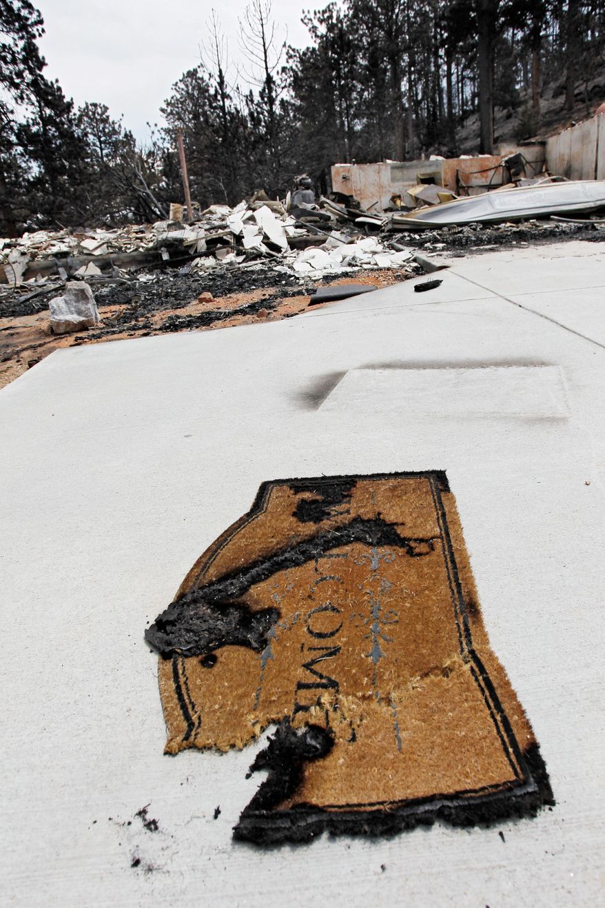 A burned welcome mat sits in front of a burned home destroyed by the High Park Fire in the Glacier View residential area near Livermore, Colo., on Monday, July 2, 2012. The last evacuees from the fire in have been allowed to return home as crews fully contained the136-square-mile wildfire that killed one resident and destroyed 259 houses. (AP Photo/Ed Andrieski)