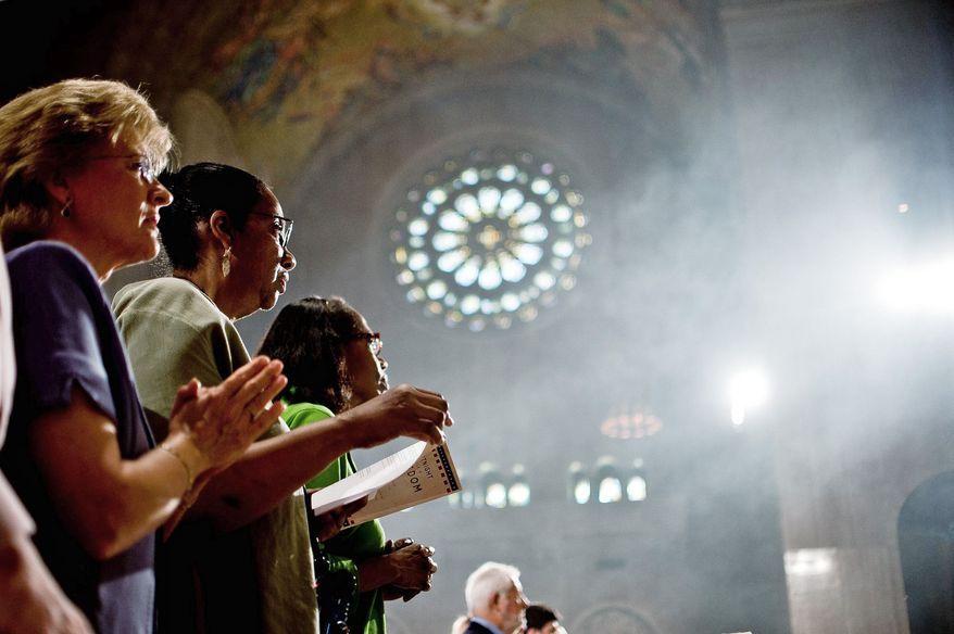 From left, Mary Ann Shutzer of Alexandria and Mary-Christine Bryant and her sister Phyllis Bryant of New York City pray during the closing Mass.