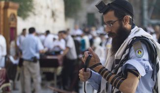 ** FILE ** In this Monday, July 2, 2012, an Israeli soldier prays next to the Western Wall, the holiest site where Jews can pray, in Jerusalem&#39;s Old City. (AP Photo/Dan Balilty)

