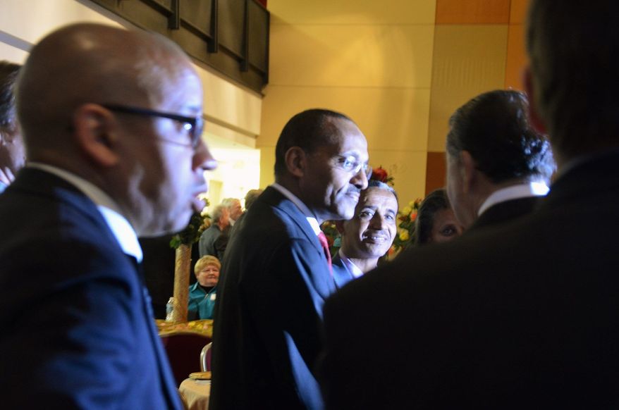Ethiopian Ambassador to the U.S. Girma Birru (center) chats with then-Metropolitan Washington Airports Authority Vice Chairman Leonard Manning in March at the embassy. In his MWAA role, Mr. Manning helped facilitate opening the U.S. market to Ethiopian roses. (Jessica Carpenter/The Washington Times)