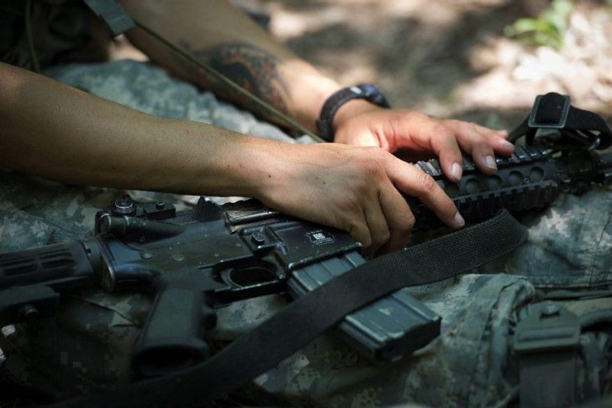 Capt. Godman sits with her weapon ready to move again as she and other trainees work to complete a mission at the Missouri training school for sappers. She was influenced in her choice of a military career by a cousin who had joined the Army and her brother, who had become a National Guardsman. (Rod Lamkey Jr./The Washington Times)