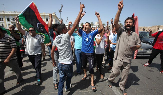 Libyans celebrate July 7, 2012, in Martyrs&#x27; Square in Tripoli, Libya, by holding up ink-marked fingers, showing they have voted in the first parliamentary election after last year&#x27;s overthrow and killing of longtime leader Moammar Gadhafi. (Associated Press)