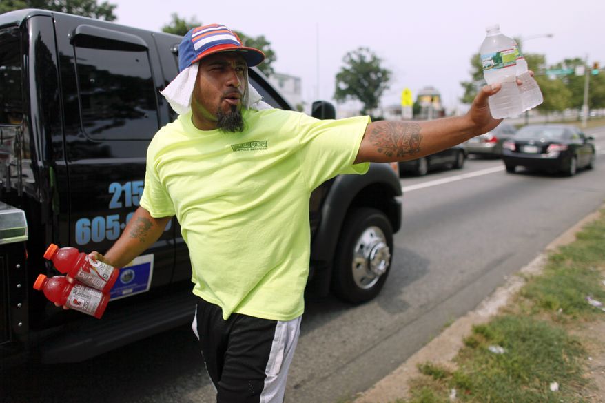 Frank Moralez sells cold beverages to motorists July 7, 2012, on Roosevelt Boulevard in the Feltonville section of Philadelphia. Temperatures of more than 100 degrees were forecast in Philadelphia and excessive heat warnings were issued for several states in the Midwest as a heat wave continued. (Associated Press)