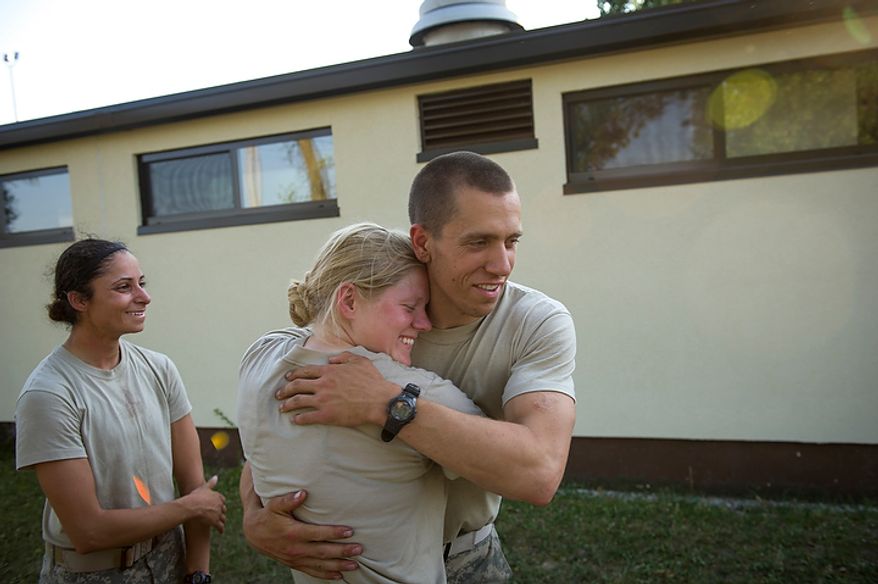 Sapper candidate and Army Captain Aston Armstrong gets a hug from Army Captain John Todd, a fellow Sapper who also passed as her friend, Sapper candidate and Army Captain Stephanie Godman (left) also celebrates their success as they hug, cry and laugh after learning they both made the cut at the conclusion of the grueling of Sapper School training course at U.S. Army Maneuver Support Center (MANSCEN) and Fort Leonard Wood in Fort Leonard Wood, Mo., Wednesday, June 27, 2012. (Rod Lamkey Jr./The Washington Times)