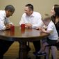 President Obama shares a laugh July 10, 2012, with Jason and Ali McLaughlin and their son, Cooper, while visiting their home in Cedar Rapids, Iowa. (Associated Press)