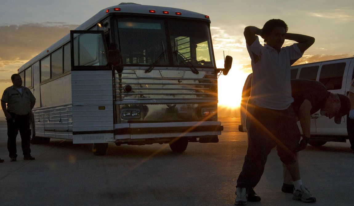 **FILE** An illegal immigrant from El Salvador is searched June 26, 2012, on the tarmac at Phoenix-Mesa Gateway Airport in Mesa, Ariz., as the sun rises prior to boarding an MD-80 aircraft for a repatriation flight of 80 immigrants to their home country. (Associated Press)