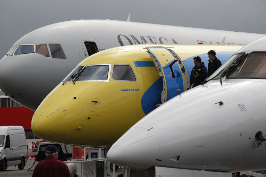 Visitors check out an aircraft on display at the Farnborough International Airshow in Farnborough, England, on Monday, July 9, 2012. (AP Photo/Sang Tan)