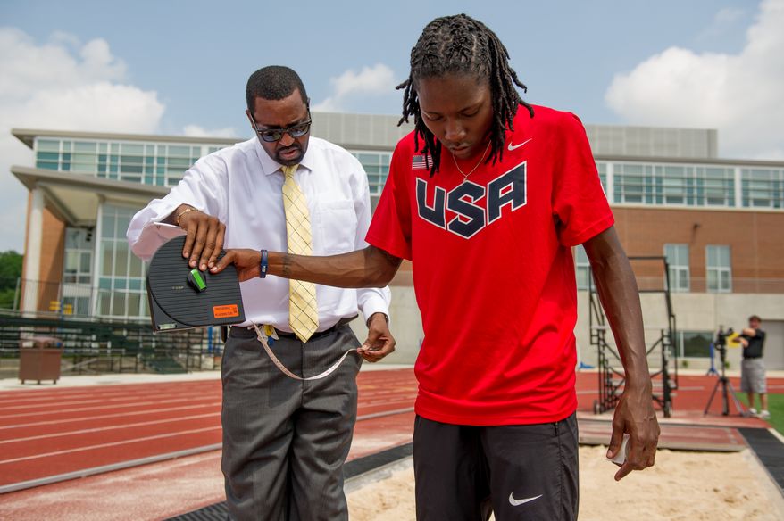 Olympic long-jumper Brittney Reese measures her distance to the sand with her coach Mark Pryor, left, while training at Coppin State University, Baltimore, Md., Friday, May 25, 2012. (Andrew Harnik/The Washington Times)