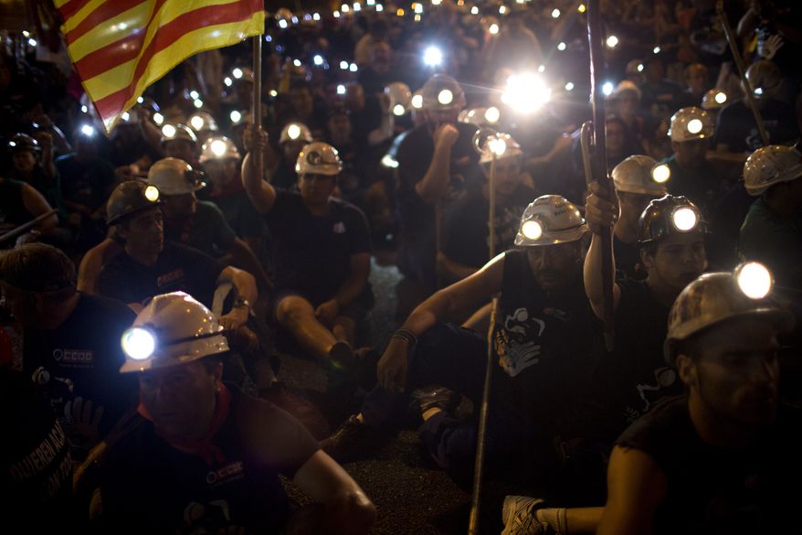 Protesting miners rest during a march after walking for more than 20 days from the northern Asturias and Leon regions on their way to the Puerta del Sol plaza in Madrid on Tuesday, July 10, 2012. (AP Photo/Emilio Morenatti)
