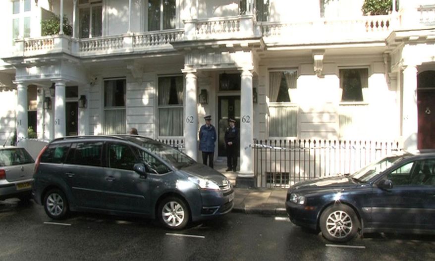 This photo taken from PA video shows police outside a house in Cadogan Place, Chelsea, after the body of Eva Rausing, a member of the family behind the Tetra-Pak drinks carton empire and one of the richest women in Britain was found, Tuesday July 10, 2012. (AP Photo/PA Video, Leanne Rinne)