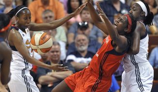 ** FILE ** Washington Mystics&#39; Crystal Langhorne, center, falls into Connecticut Sun&#39;s Tina Charles, right, after losing the ball as Sun&#39;s Allison Hightower watches during the first half of a WNBA basketball game in Uncasville, Conn., Wednesday, July 11, 2012. (AP Photo/Jessica Hill)