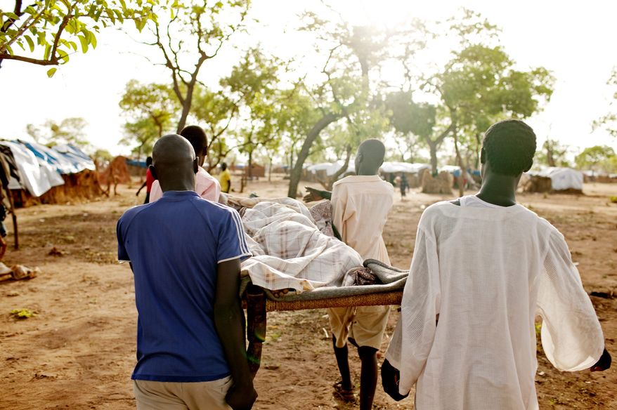 Men carry an extremely sick girl to the only medical center in the Yida refugee camp in Unity State, South Sudan on Saturday, May 12, 2012. With more than 30,000 residents, many of whom are undernourished, the few international aid organizations operating in Yida struggle to provide sufficient services. (Associated Press)