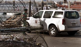 Emirati police and other officials inspect a boat docked in a fishing harbor in the Jumeirah district of Dubai, United Arab Emirates, on July 16, 2012. A U.S. official in Dubai said an American vessel fired on a boat off the coast of the United Arab Emirates, killing one person and injuring three. (Associated Press)