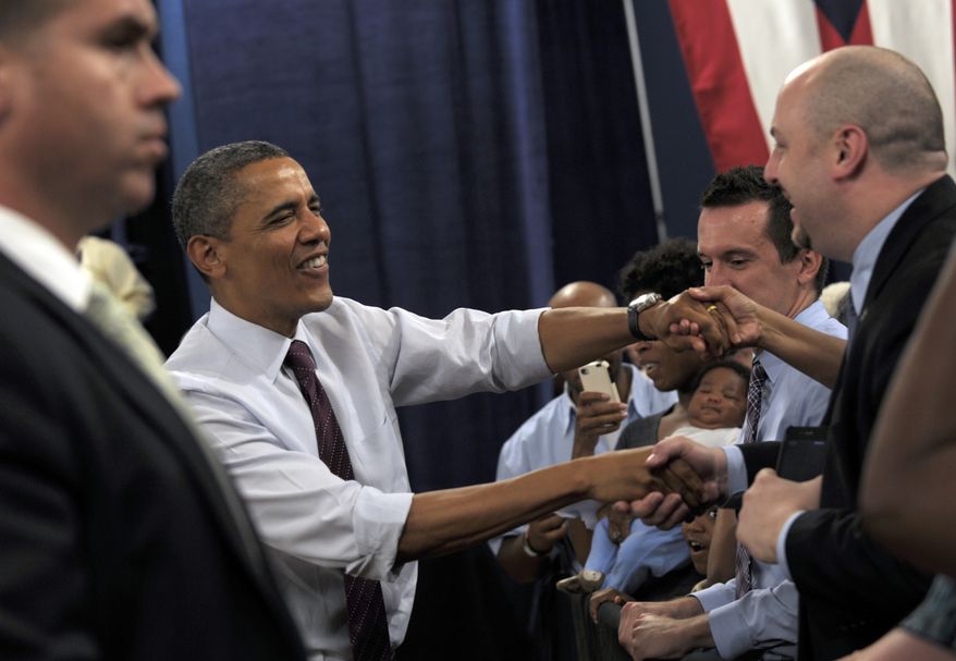 President Obama greets the crowd July 16, 2012, as he arrives to speak at a campaign event at the Cincinnati Music Hall in Cincinnati. (Associated Press)