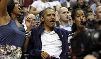 First lady Michelle Obama, from left, President Barack Obama, and daughter Malia Obama react as they watch Team USA and Brazil during the first half of an Olympic exhibition basketball game, Monday, July 16, 2012, in Washington. (AP Photo/Alex Brandon)