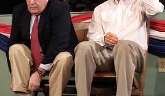 ** FILE ** Republican presidential candidate Mitt Romney (right) prepares to speak on Friday, Nov. 3, 2011, at the town hall in Exeter, N.H., as former Gov. John Sununu pulls up his socks. (Associated Press)