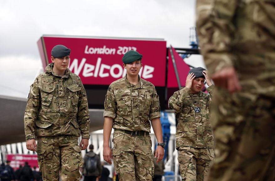 British military personnel walk July 18, 2012, near the Aquatics Center at the Olympic Park in London. Opening ceremonies for the London Olympics will be held July 27, 2012. (Associated Press)