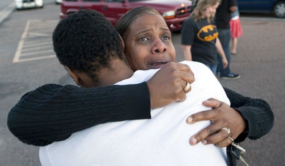 Shamecca Davis hugs her son, Isaiah Bow, outside Gateway High School in Aurora, Colo., where witness were brought for questioning after a gunman opened fire in a crowded movie theater, killing 12 people and injuring at least 50 others. Bow, who was an eyewitness, left the theater during the shooting but went back in to find his girlfriend. &quot;I didn&#39;t want to leave her in there. But she&#39;s OK now,&quot; Bow said. (Associated Press)