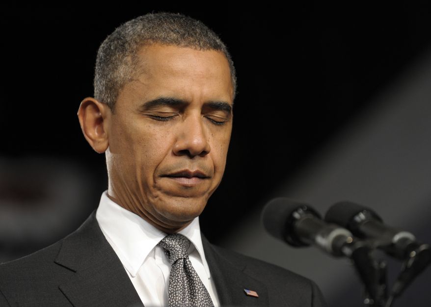 President Obama pauses July 20, 2012, during an event at the Harborside Event Center in Ft. Myers, Fla., for a moment of silence for the victims of the shooting at an Aurora, Colo., movie theater that left 12 people dead. (Associated Press)