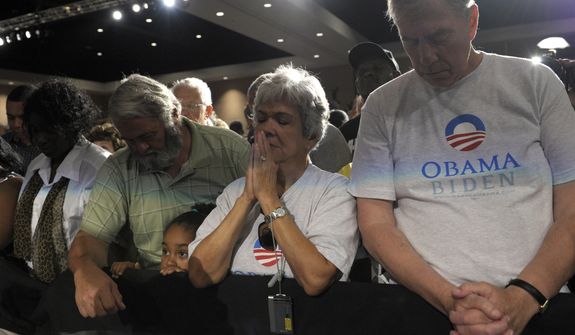 People observe a moment of silence July 20, 2012, at an event at the Harborside Event Center in Ft. Myers, Fla., with President Obama for the victims of the Aurora, Colo., shooting. Obama, who was scheduled to spend the day campaigning in Florida, cancelled his campaign events to return to Washington to monitor the shooting. (Associated Press)